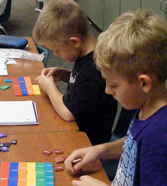 Two students use blocks in a class project